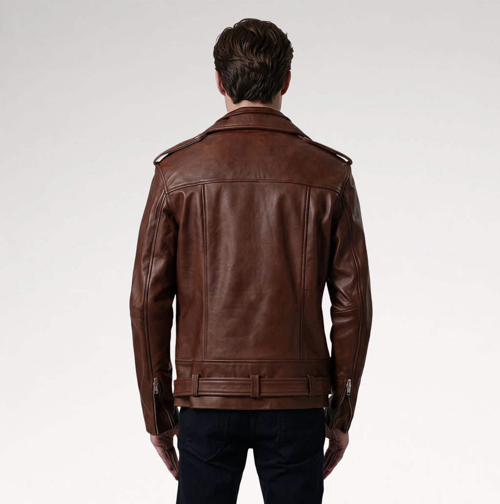 A man viewed from behind wearing a brown leather motorcycle jacket with a belted waist and zippered sleeve details, paired with dark pants, against a light gray studio background.