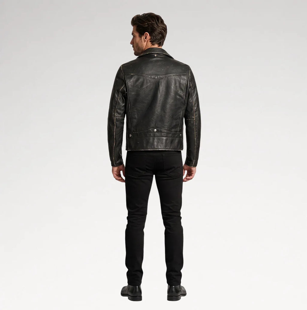 A man viewed from the back wearing a black leather jacket, black slim-fit jeans, and black shoes, standing against a light gray studio background.