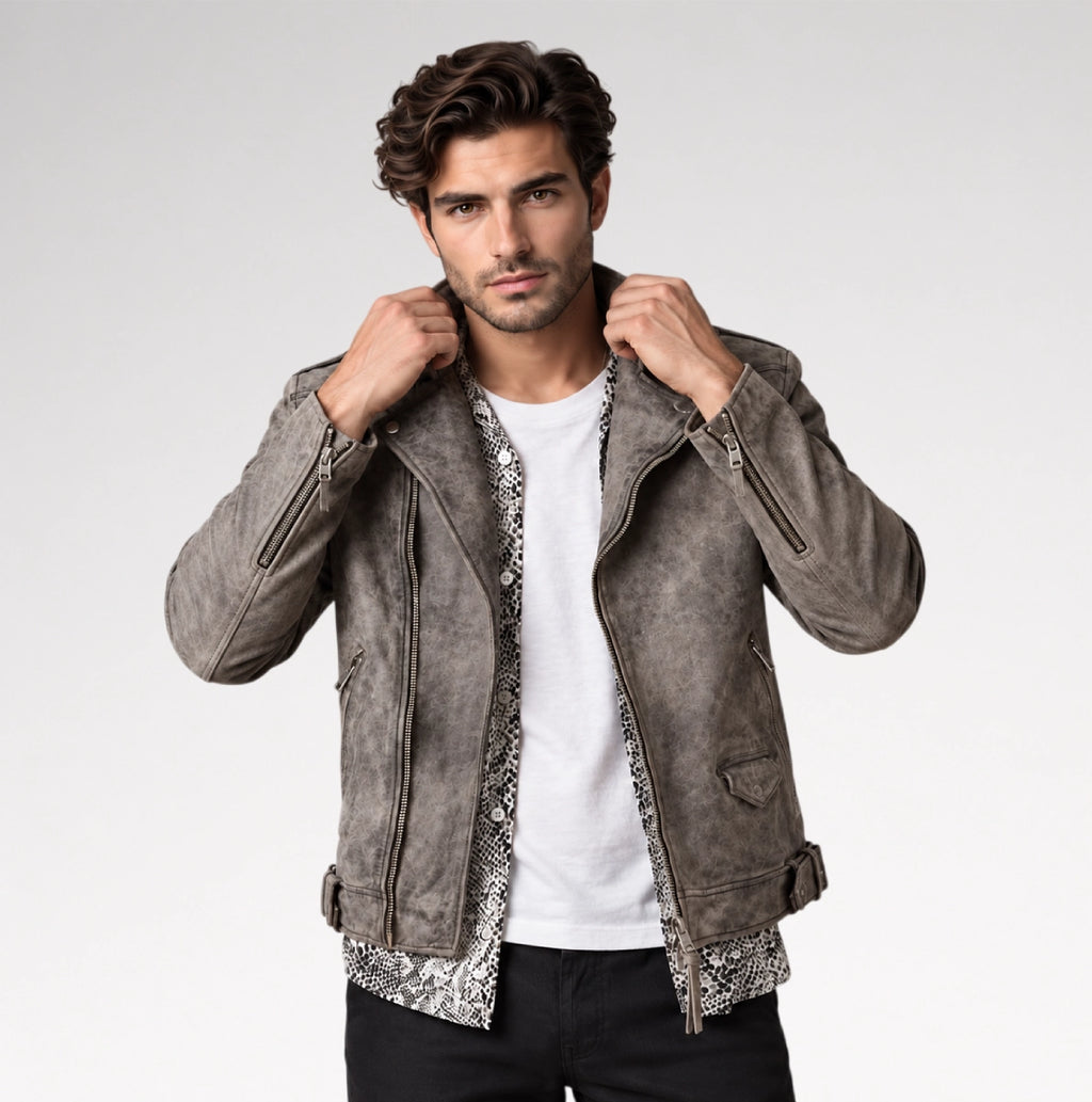 A man wearing a gray faux-suede motorcycle jacket over a white t-shirt and black pants, posing against a light gray studio background.