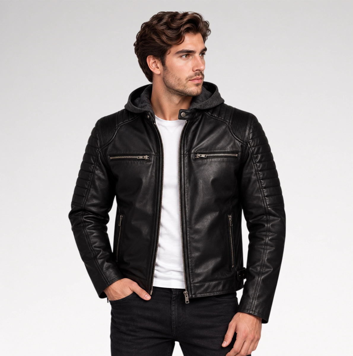 A man wearing a black leather hooded biker jacket with quilted shoulder panels, zippered chest pockets, and a white t-shirt underneath, photographed against a light gray studio background. Main image
