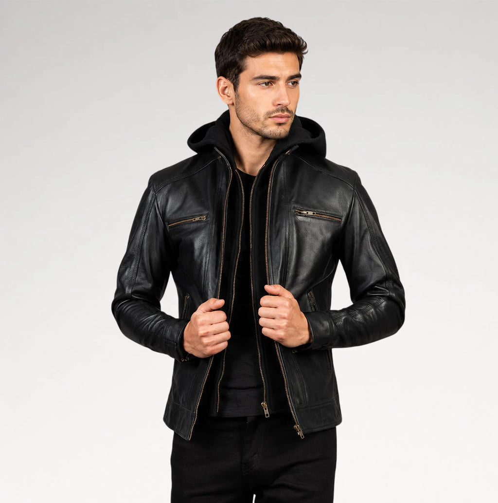 A man wearing a black leather hooded jacket with zippered chest pockets, posed against a light gray studio background.