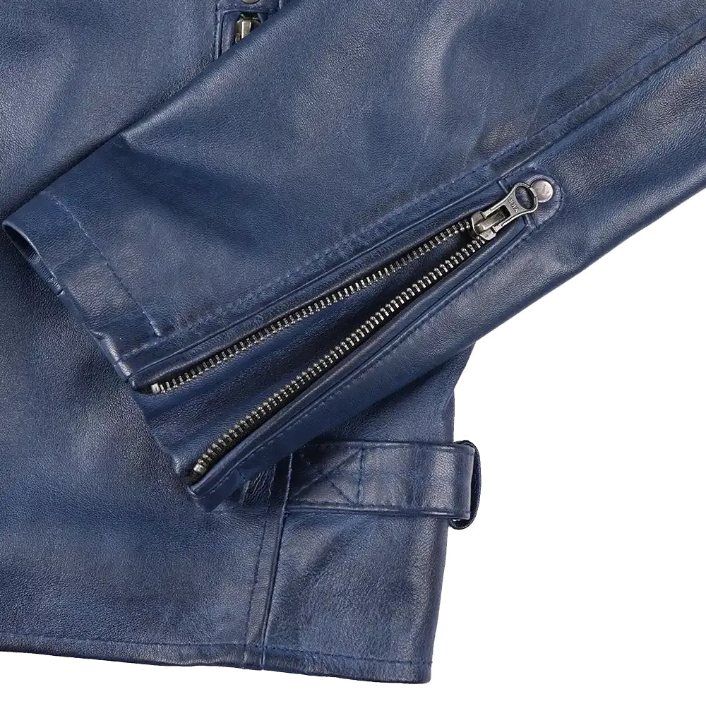 Close-up of a navy blue faux leather jacket showing the sleeve with dual silver zipper details and a matching belt buckle closure, set against a plain white background.