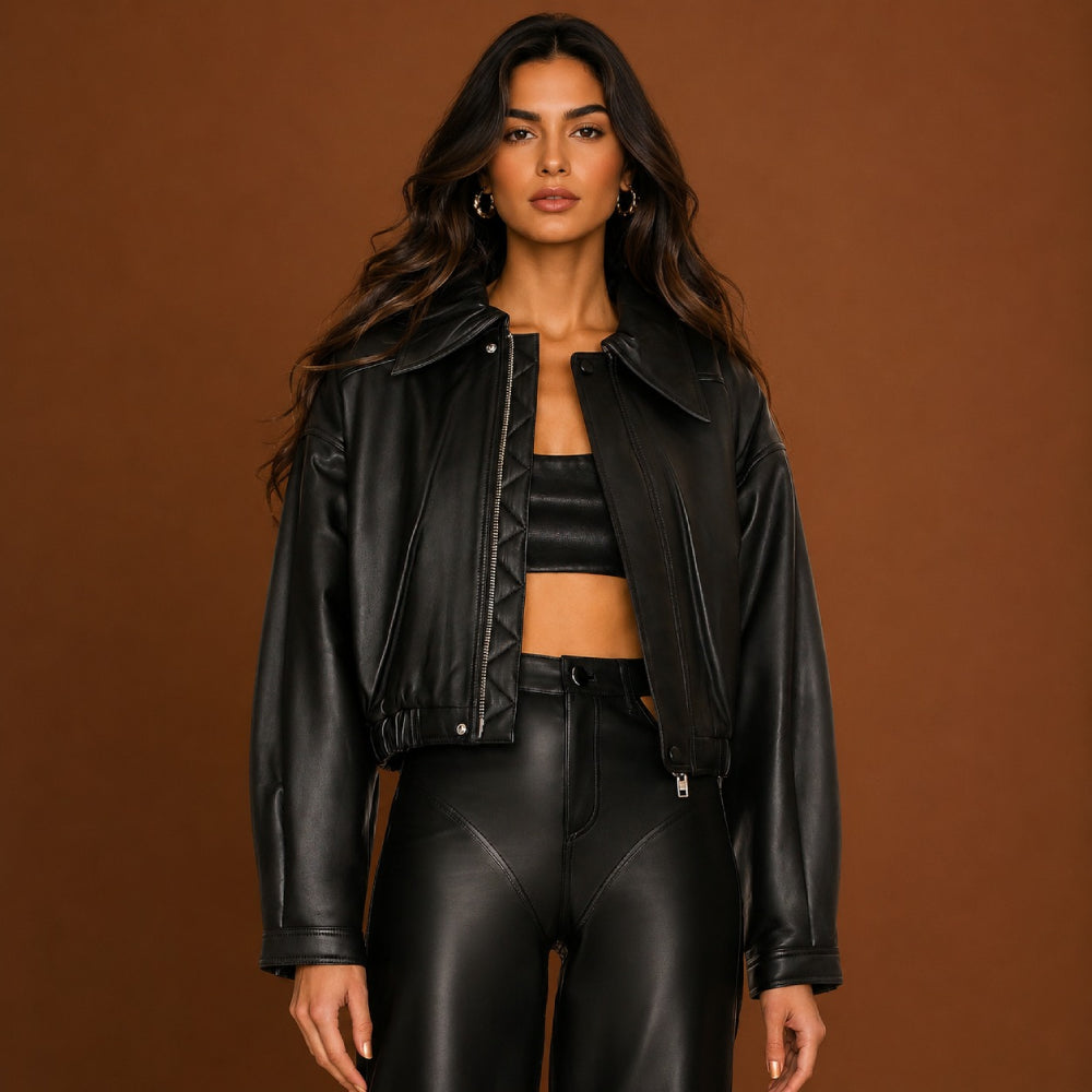 Person wearing a black leather jacket and pants against a brown background
