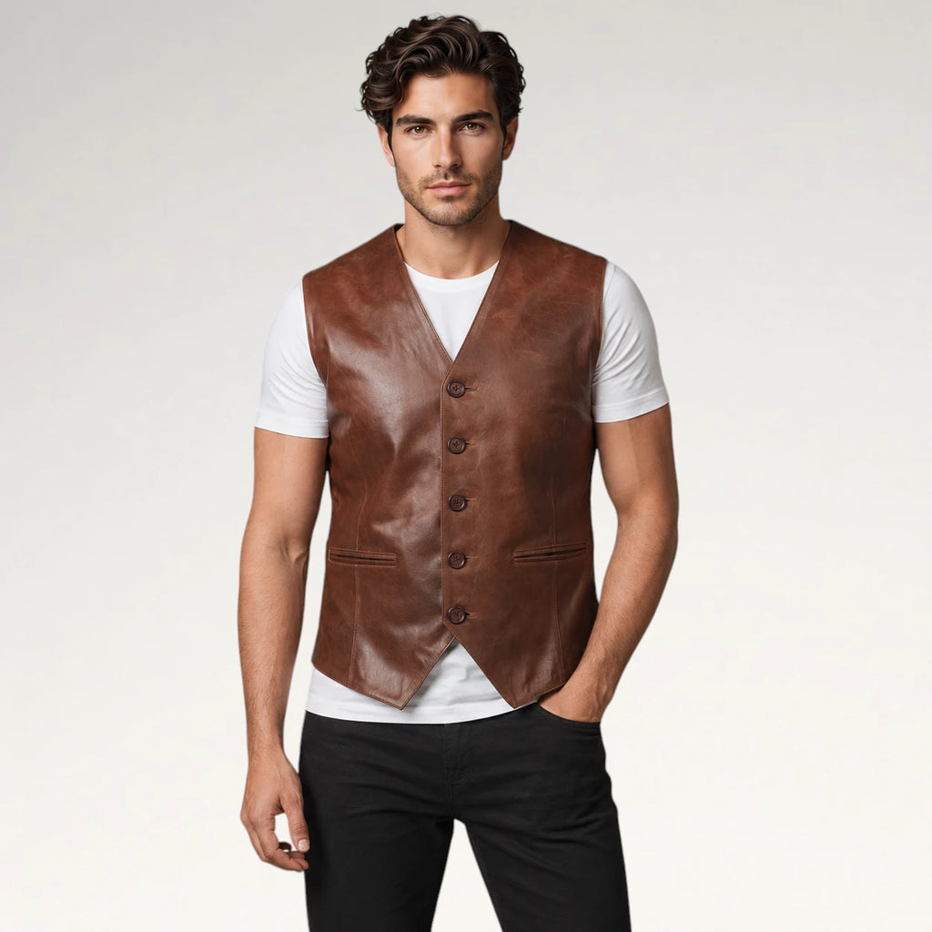 A man modeling a brown leather vest over a white t-shirt and black pants, standing against a light gray studio background.