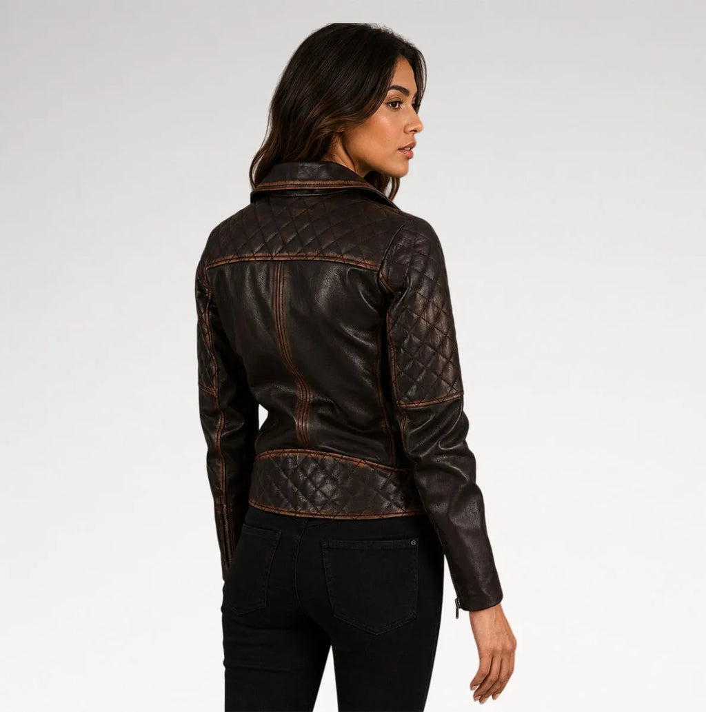 A woman shown from the back wearing a dark brown quilted faux-leather jacket with contrast stitching, paired with black pants, against a light gray studio background.
