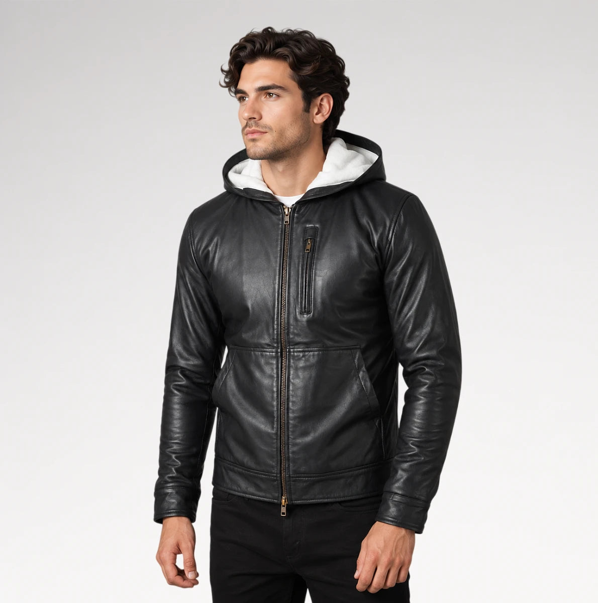 A man wearing a black leather hooded jacket with a white hood lining, standing against a light gray studio background. Main image