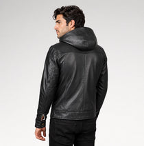 A man wearing a black leather hooded jacket, shown from a rear three-quarter angle against a light gray studio background.