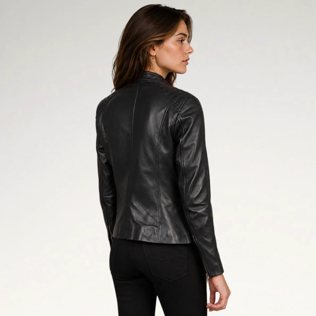 A woman wearing a black leather jacket, shown from a side-back angle against a plain light gray studio background.