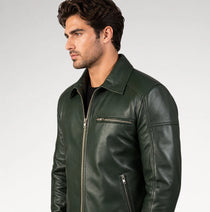 A man wearing a dark forest green leather jacket with silver zippers, shown in a side profile against a light gray studio background.