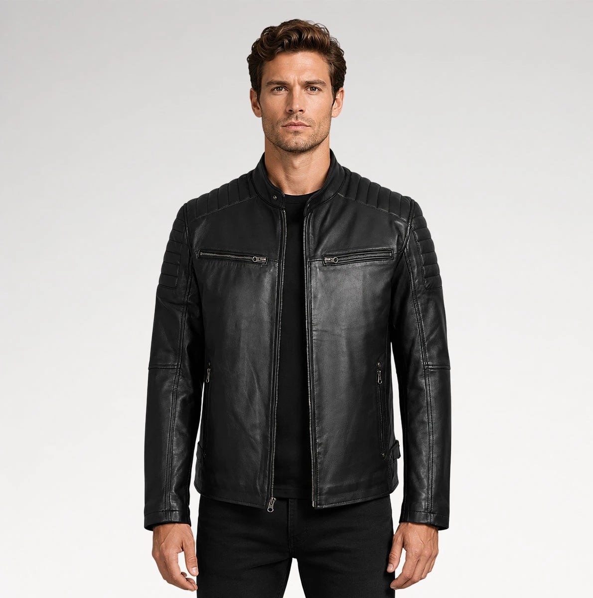A man wearing a black leather jacket with quilted shoulder panels, zippered chest pockets, and a ribbed hem, photographed against a light gray studio background. Main image