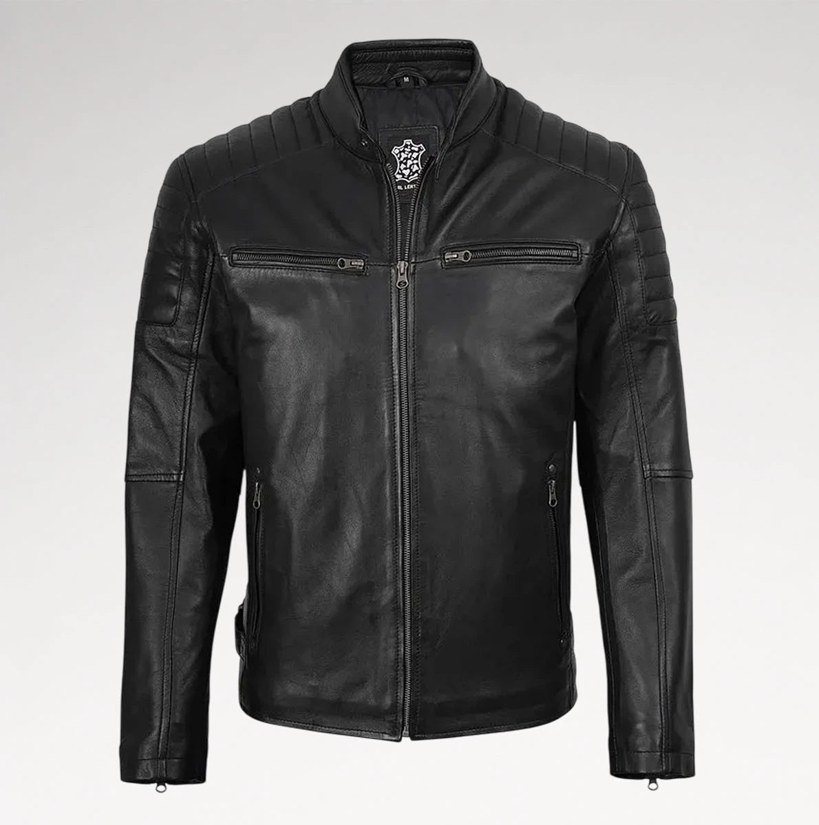 A black leather motorcycle jacket with a stand collar, quilted shoulder panels, zippered chest pockets, and a silver-toned decorative emblem on the collar, shown against a light gray background.