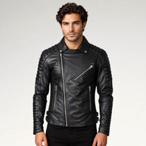 A man wearing a black leather biker jacket with silver zippers, photographed against a light gray studio background.