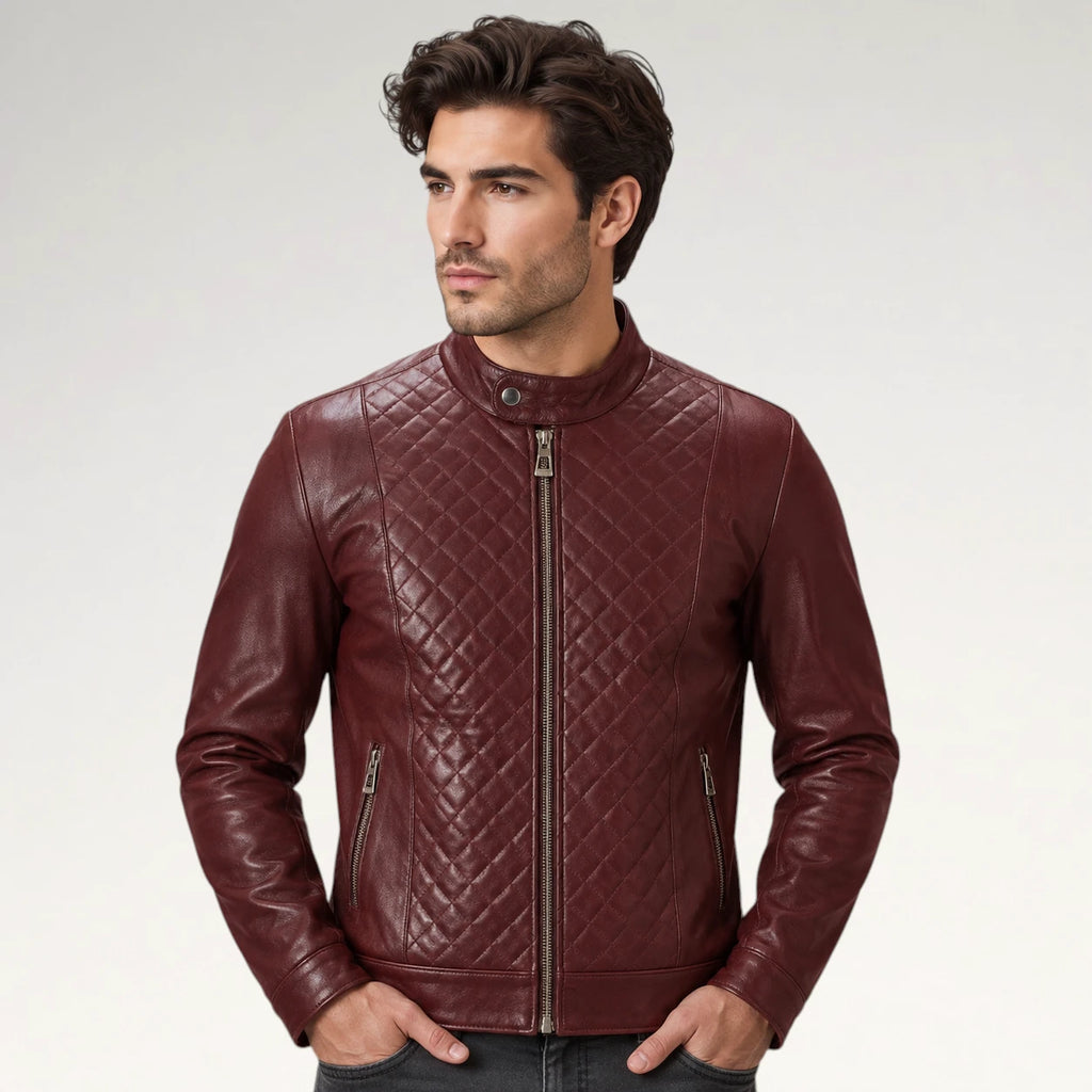 A man wearing a burgundy quilted leather jacket with a stand-up collar and front zipper, photographed against a light gray studio background.