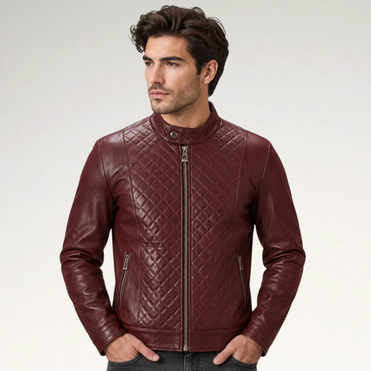A man wearing a burgundy quilted leather jacket with a stand-up collar and front zipper, photographed against a light gray studio background.