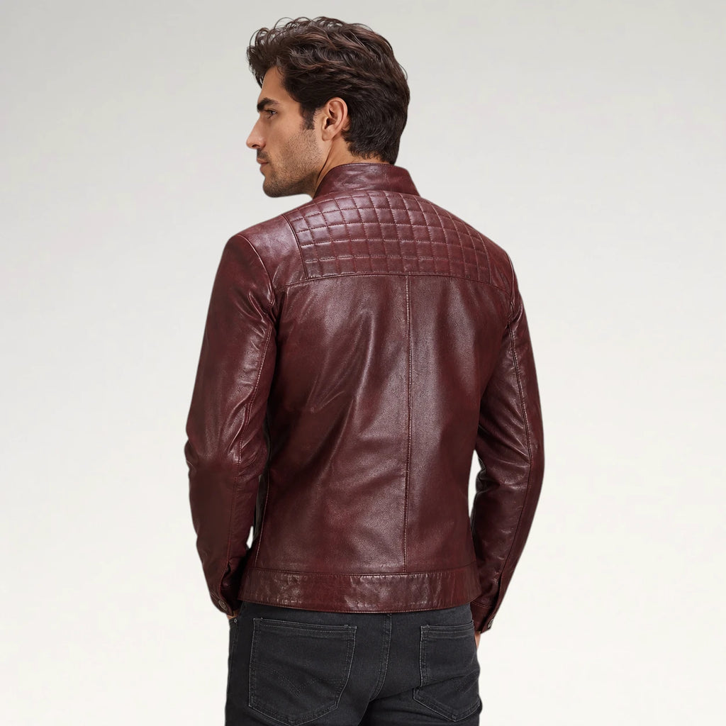 A man wearing a dark burgundy leather jacket, shown from the back against a light gray studio background.