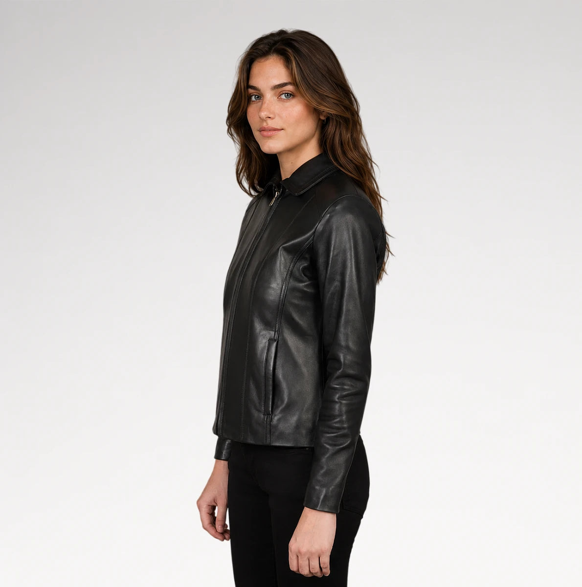 A woman wearing a black leather jacket with a collar and front zipper, shown in profile against a light gray studio background.