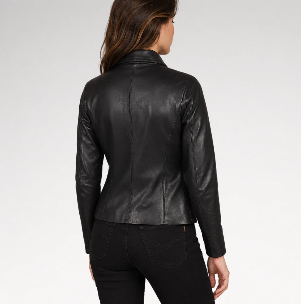 A woman viewed from the back wearing a fitted black leather jacket and black pants against a light gray studio background.