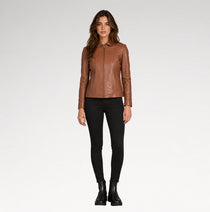 A woman modeling a brown leather jacket with a collar and front zipper, paired with black skinny pants and black ankle boots, against a light gray studio background.