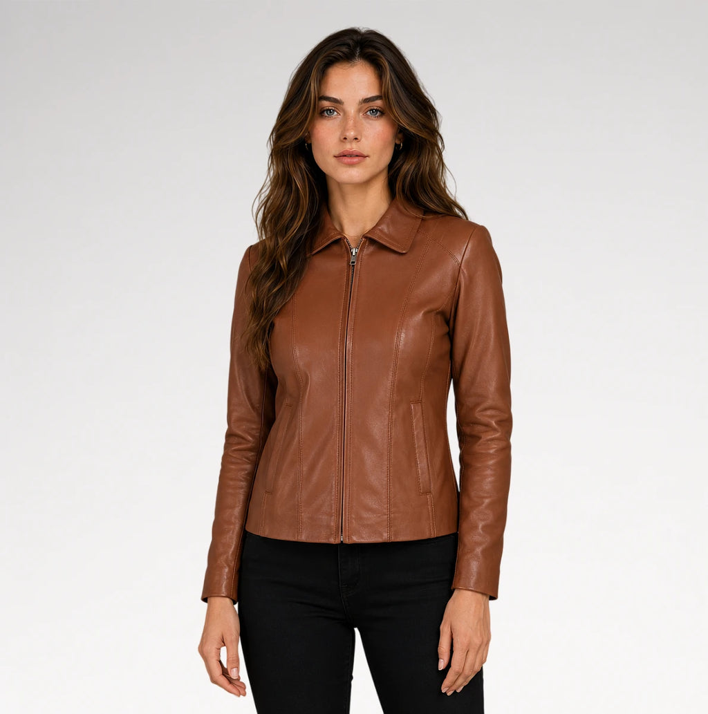 A woman modeling a brown leather jacket with a front zipper and collar, paired with black pants, against a light gray studio background.