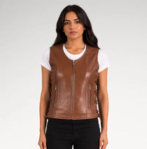 A woman modeling a brown faux-leather zip-front vest over a white t-shirt and black pants, photographed against a light gray studio background.
