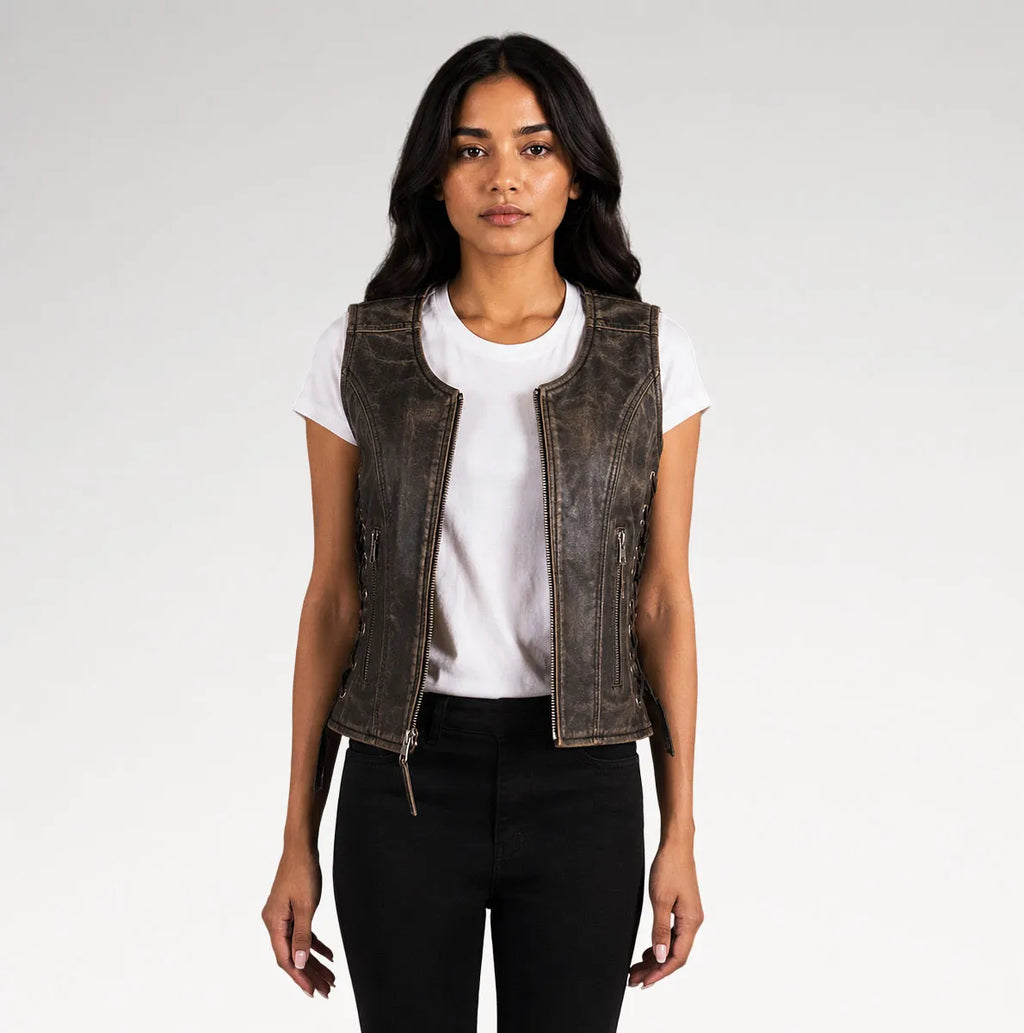 A woman modeling a distressed dark brown leather vest over a white t-shirt and black pants, photographed against a light gray studio background.