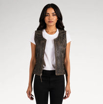 A woman modeling a distressed dark brown leather vest over a white t-shirt and black pants, photographed against a light gray studio background.