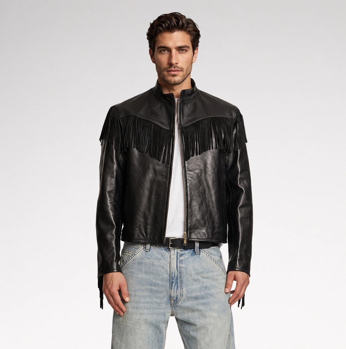 A man modeling a black leather jacket with fringe detailing across the chest, paired with a white t-shirt and light blue jeans, against a plain light gray studio background. Main image