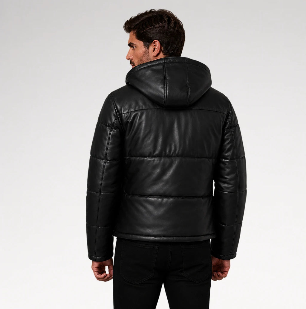A man wearing a black puffer jacket with a hood, shown from the back against a light gray studio background.