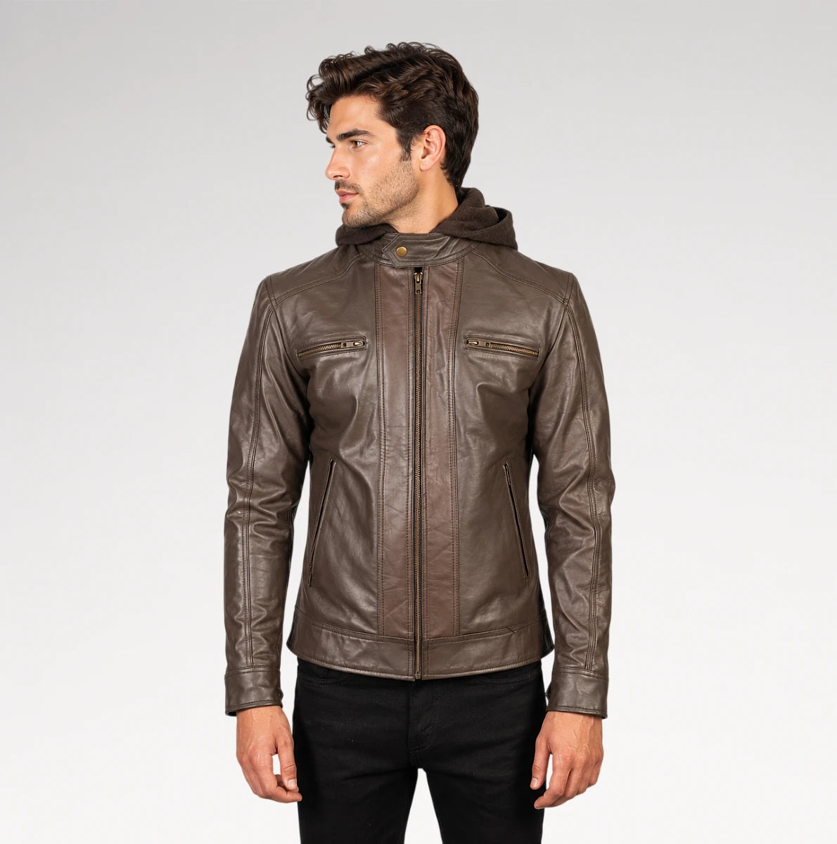 A man wearing a brown leather hooded jacket with zippered chest pockets, shown from the waist up against a light gray studio background.