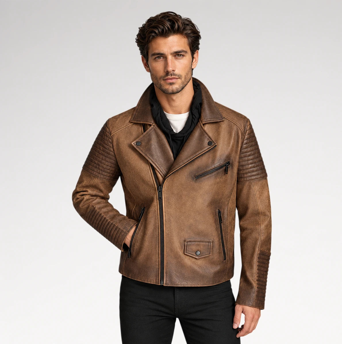 A man wearing a brown faux-leather biker jacket with quilted shoulder panels, a front zipper, and zippered pockets, paired with black pants and a black shirt, against a light gray studio background. Main image