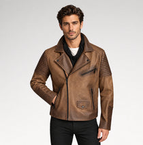 A man wearing a brown faux-leather biker jacket with quilted shoulder panels, a front zipper, and zippered pockets, paired with black pants and a black shirt, against a light gray studio background.