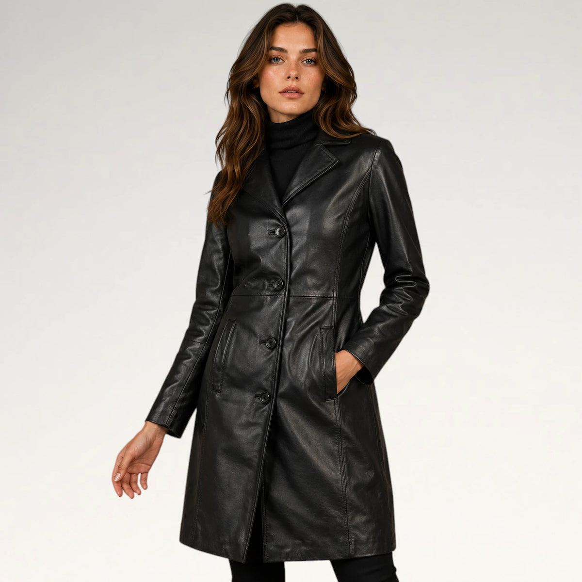 A woman modeling a black faux-leather double-breasted coat over a black turtleneck, photographed against a clean white studio background. Main image
