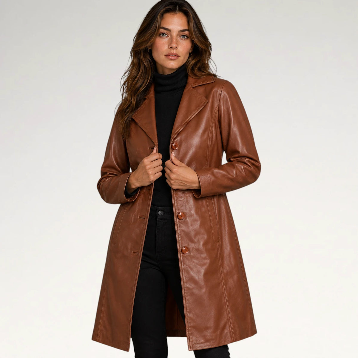A woman modeling a brown faux-leather coat over a black turtleneck and black pants, photographed against a clean light gray studio background. Main image