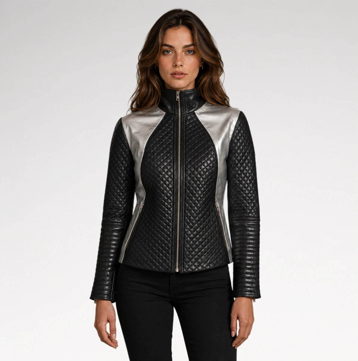 A woman modeling a black quilted faux-leather jacket with metallic silver side panels and a silver front zipper, paired with black pants against a light gray studio background.