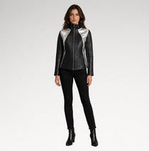 A model stands against a light gray studio background wearing a black quilted faux-leather jacket with metallic silver shoulder panels, black skinny pants, and black ankle boots.