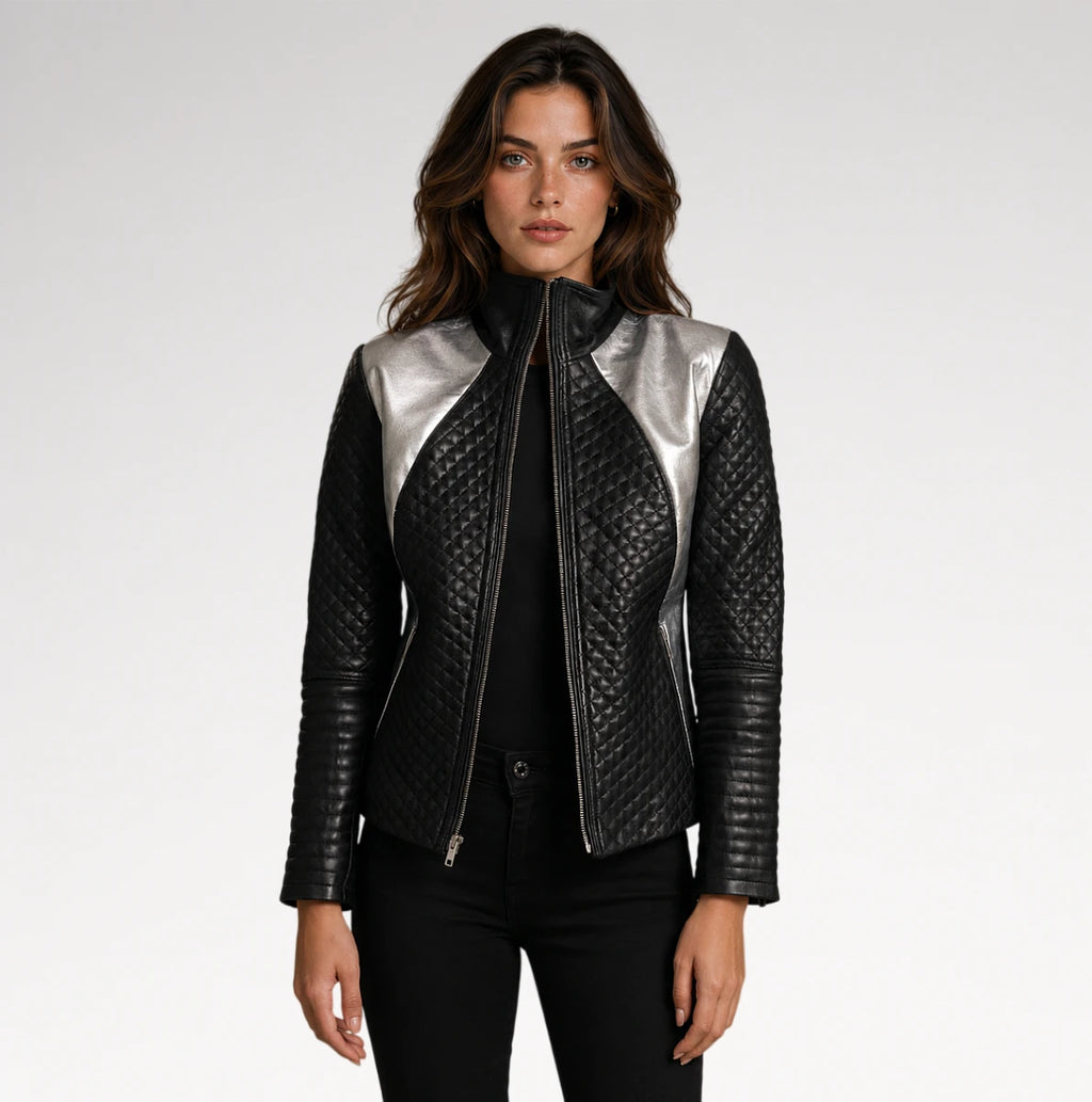 A woman modeling a black quilted leather jacket with metallic silver shoulder panels, styled with a black top and black pants against a light gray studio background.