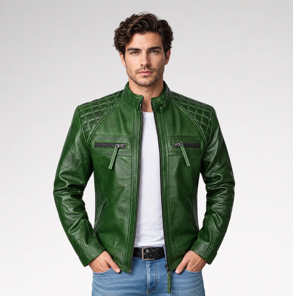 A man wearing a dark green leather motorcycle jacket with quilted shoulder panels, zippered chest pockets, and a white t-shirt underneath, standing against a light gray studio background.