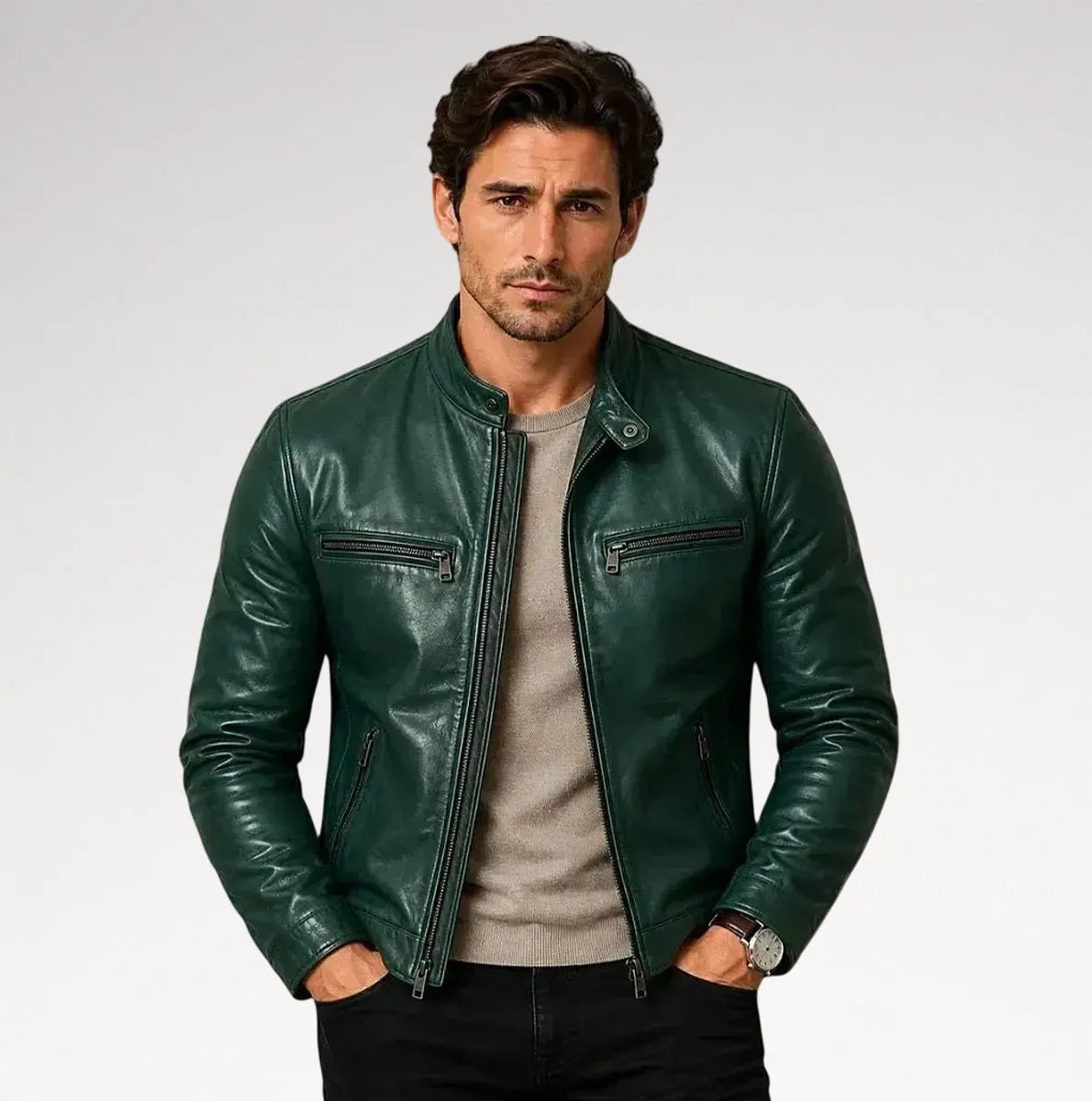 A man wearing a dark green leather jacket over a light gray crewneck sweater and black pants, standing against a light gray studio background. Main image