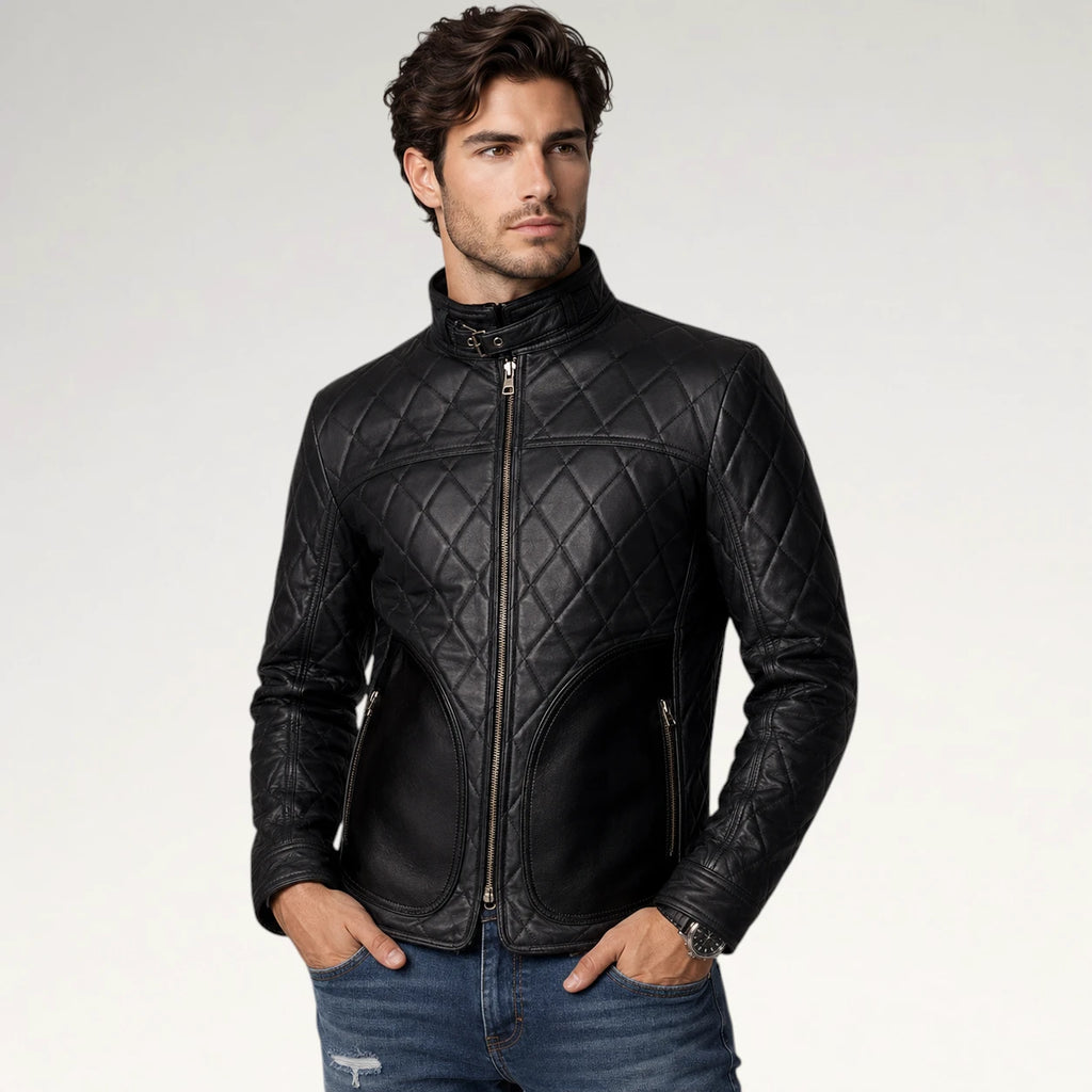 A man wearing a black quilted leather jacket with a high collar and front zipper, paired with blue jeans, photographed against a light gray studio background.