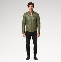 A man modeling an olive green leather jacket with black pants and black boots, standing against a light gray studio background.
