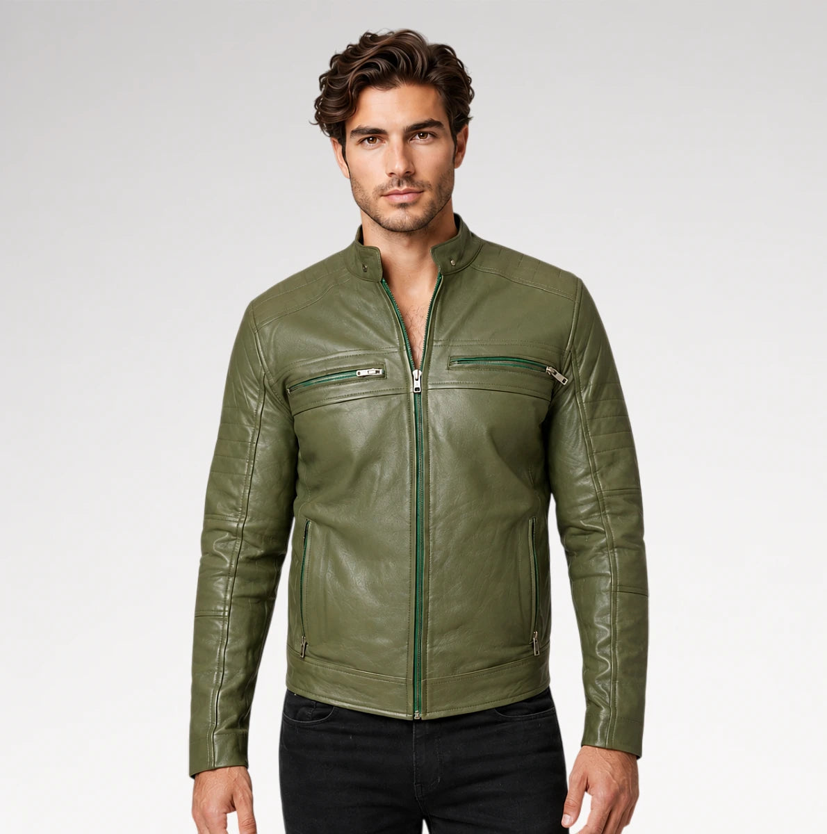 A man wearing a fitted olive green leather jacket with a front zipper, zip chest pockets, and zip hand pockets, paired with black pants, against a light gray studio background.