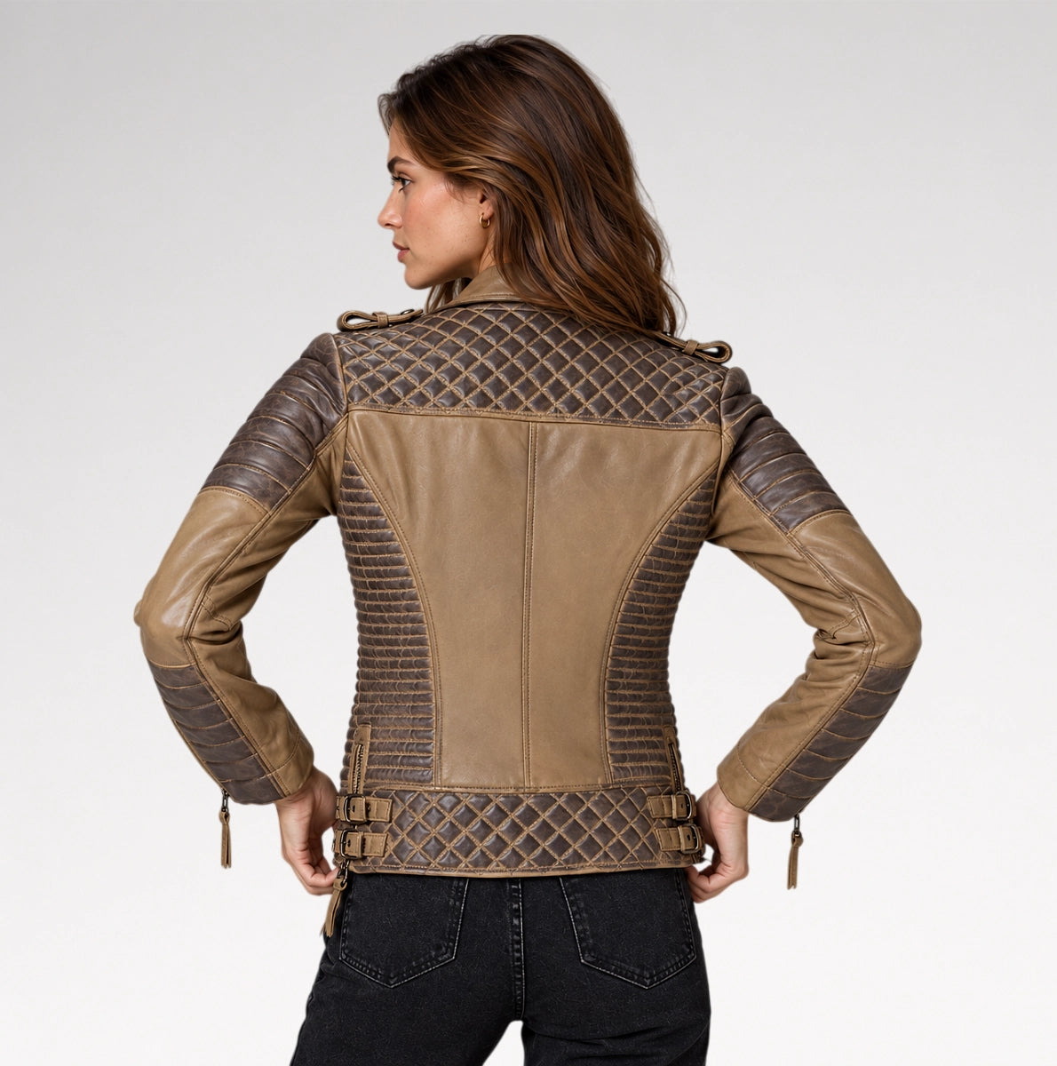 A woman shown from the back wearing a tan and dark brown faux-leather motorcycle jacket with quilted diamond-patterned panels and ribbed sleeves, paired with black jeans, against a light gray studio background.