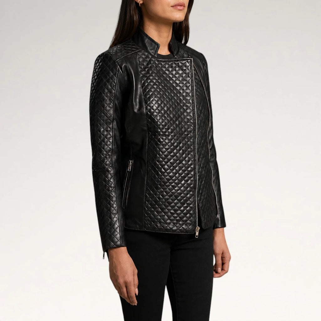 A woman wearing a black quilted faux-leather moto jacket with asymmetrical zipper details, shown from the waist up against a light gray studio background.