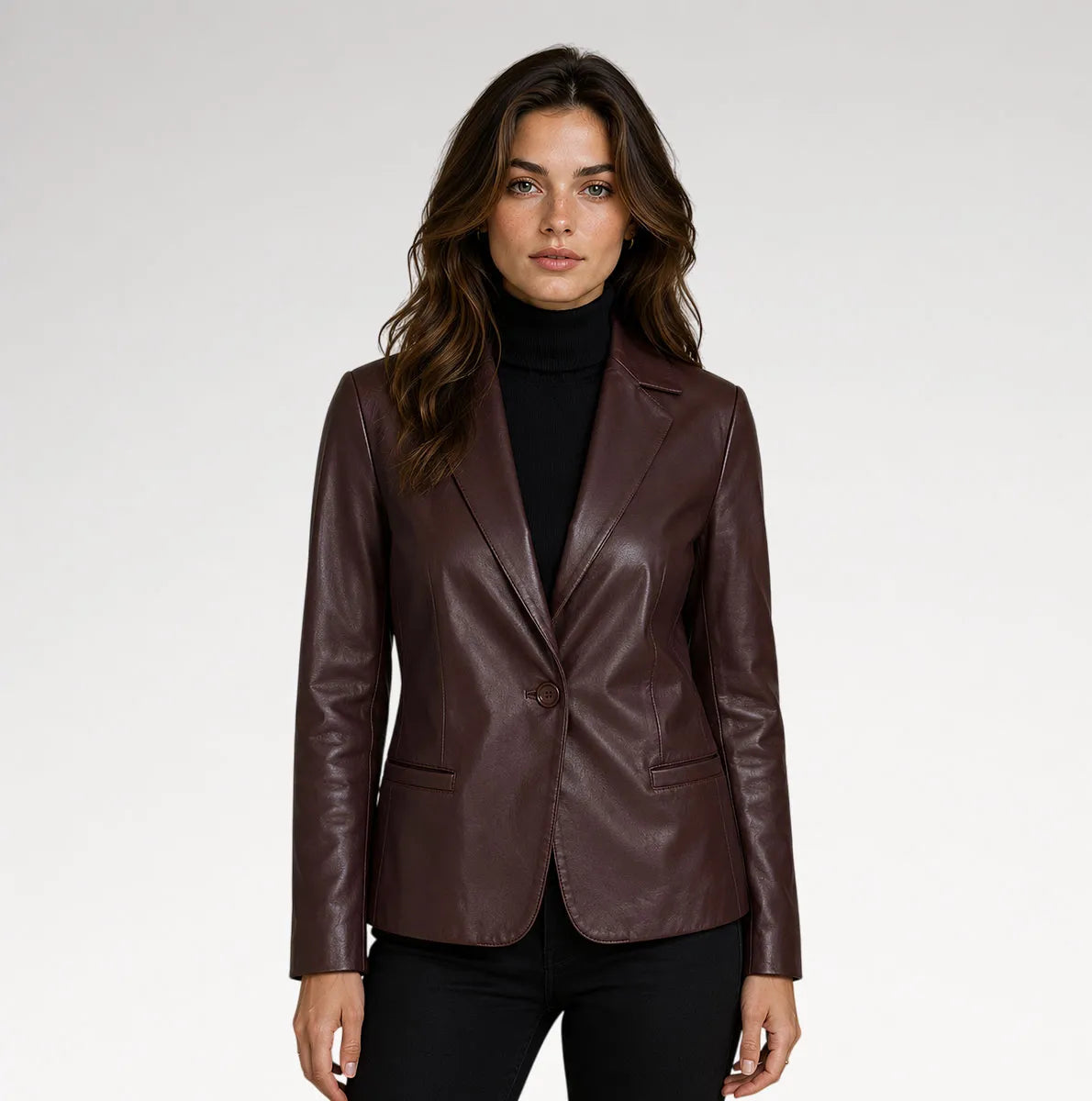 A woman modeling a dark brown faux-leather blazer over a black turtleneck sweater and black pants, photographed against a neutral light gray studio background. Main image
