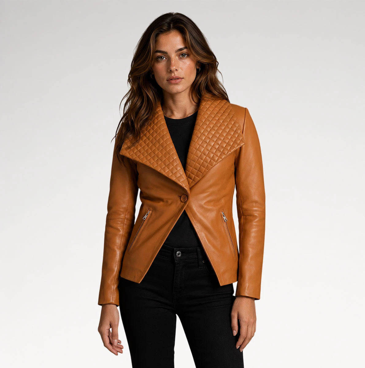 A woman modeling a tan leather moto jacket with a quilted asymmetrical yoke and black pants against a light gray studio background. Main image