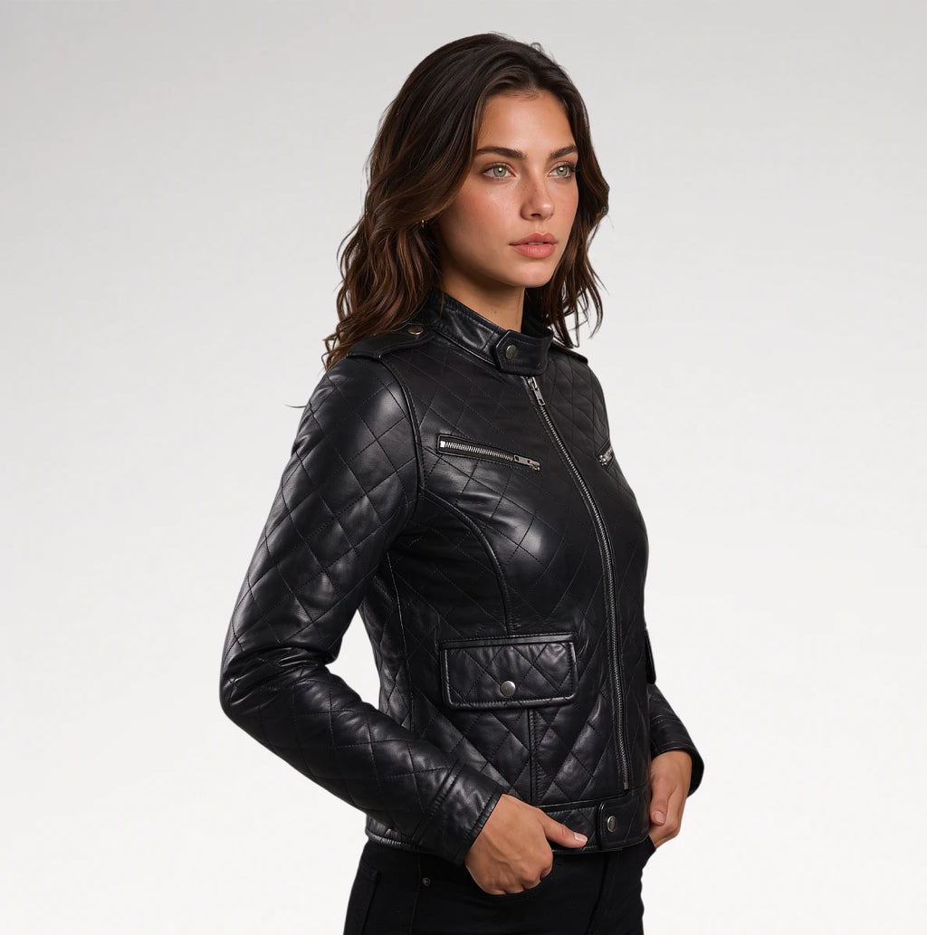 A woman modeling a black quilted leather moto jacket with silver zippers, photographed against a clean light gray studio background.