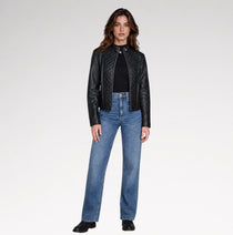 A women is wearing black quilted leather jacket in a grey background with a full pose. 