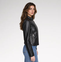 A women is wearing quilted leather jacket in a grey background with a side pose.