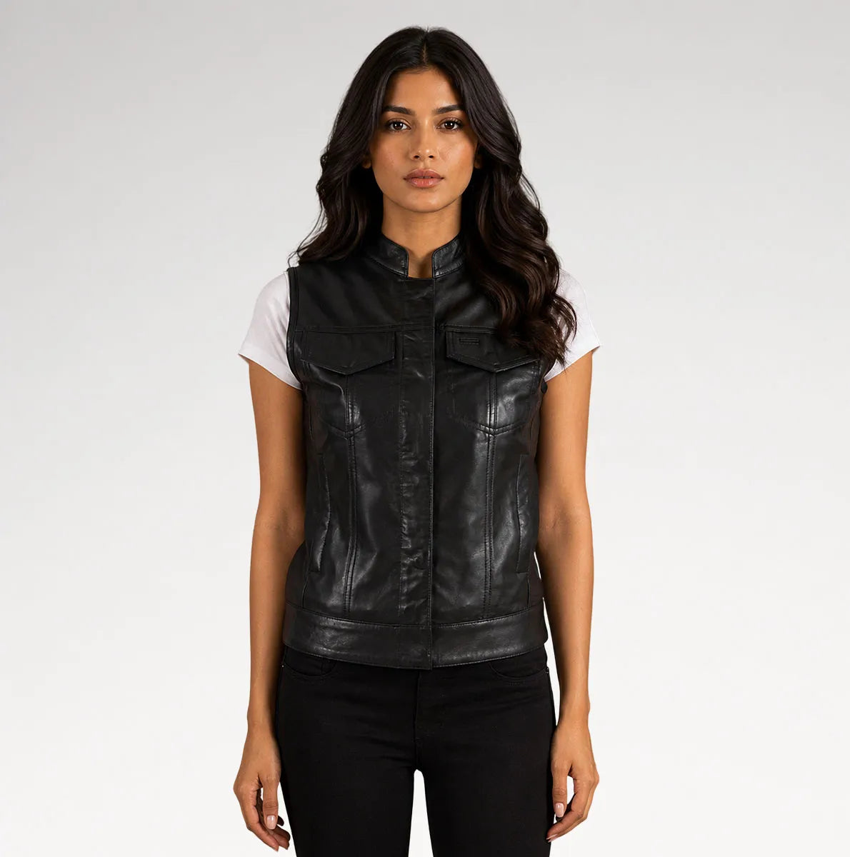 A woman modeling a black faux-leather vest with a stand-up collar and front flap pockets, worn over a white t-shirt and black pants, against a light gray studio background. Main image
