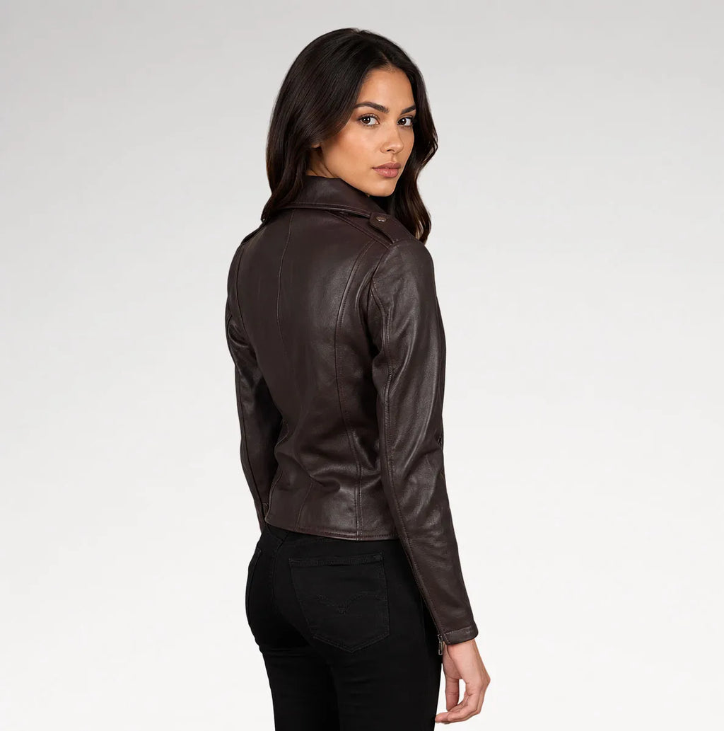 A woman wearing a dark brown leather jacket, shown from a three-quarters back view against a light gray studio background.